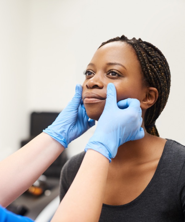 Dermatologist examining woman's face
