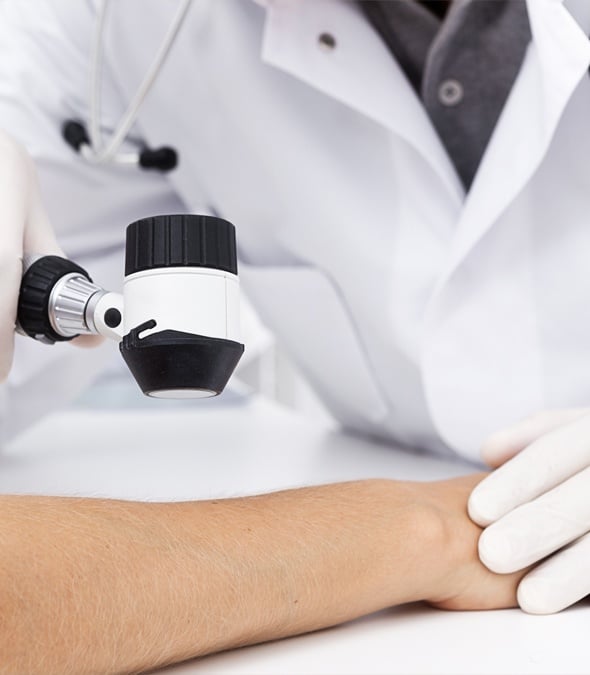 Dermatologist inspecting a patient's arm